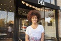 Black female business owner standing in street outside cafe Royalty Free Stock Photo