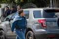 A black female detective from LAPD`s metro division walks by police vehicles