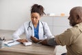 Black female doctor checking measuring pressure on patient's hand Royalty Free Stock Photo