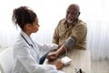 Black female doctor checking measuring pressure on patient& x27;s hand Royalty Free Stock Photo