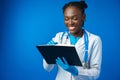 Black female doctor student wearing a lab coat with book Royalty Free Stock Photo