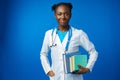 Black female doctor student wearing a lab coat with book Royalty Free Stock Photo