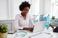 Black female doctor at work in office using laptop computer