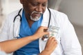 Black female hand putting money in doctor's pocket Royalty Free Stock Photo