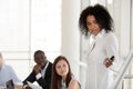 Black female mentor make presentation on flipchart training empl