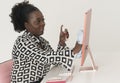 Black female office worker cleaning computer screen. Smiling woman. Royalty Free Stock Photo