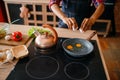 Black female person cooking fried eggs on kitchen