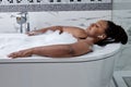Black female relaxing in hotel spa bathtub or home bathroom for total relaxation Royalty Free Stock Photo