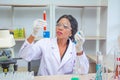 Black female scientist or doctor in protective glasses and gloves testing tube antivirus ingredient in laboratory,concept research