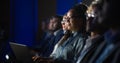 Black Female Sitting in Dark Crowded Auditorium at an International Business Conference. Multiethnic Royalty Free Stock Photo