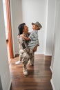 Black female soldier holds son on arms at home