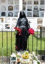 Black Female statue with red froses and flower in her hands