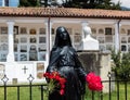 Black Female statue with red froses and flower in her hands