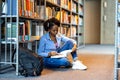 Black female student reading a book in a library Royalty Free Stock Photo