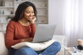 Black Female Surfing Internet On Laptop And Relaxing On Couch At Home Royalty Free Stock Photo