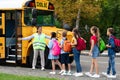 Black Female Teacher Assisting Children While They Entering School Bus Royalty Free Stock Photo