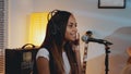 Black female vocalist in headphone recording her new song in home studio Royalty Free Stock Photo