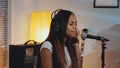 Black female vocalist in headphone recording her new song in home studio Royalty Free Stock Photo