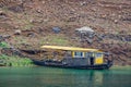 Black ferry at yellow floating pier along Daning River, Wuchan, China