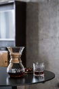 Black filtered coffee in chemex and glass on table Royalty Free Stock Photo