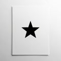 A black five pointed star is centered on a stack of white sheets of paper Royalty Free Stock Photo