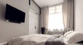 Black flat empty tv screen hanging on wall of modern white bedroom or hotel room