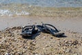 black flip flops on the beach, summer vacations Royalty Free Stock Photo