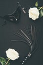 Black flogging whip and mask with white roses