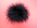 Black fluffy feather ball on pink background Royalty Free Stock Photo