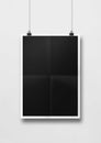 Black folded poster hanging on a white wall with clips Royalty Free Stock Photo