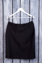 Black folded striped trousers on hanger.