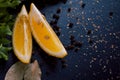 Black food background with slices of lemon, fresh aromatic herbs and spices, copy space, top view Royalty Free Stock Photo