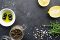 Black food frame background with fresh aromatic herbs and spices, copy space, top view. Allspice, thyme, lemon, olives Royalty Free Stock Photo