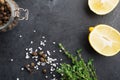 Black food frame background with fresh aromatic herbs and spices, copy space, top view. Allspice, thyme, lemon, olives Royalty Free Stock Photo