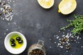 Black food frame background with fresh aromatic herbs and spices, copy space, top view. Allspice, thyme, lemon, olives Royalty Free Stock Photo