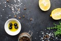 Black food frame background with fresh aromatic herbs and spices, copy space, top view. Allspice, thyme, lemon, olives Royalty Free Stock Photo