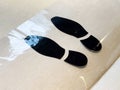 Black footprint decals on beige surface Royalty Free Stock Photo