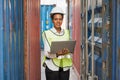 Black foreman woman worker working checking at Container cargo harbor holding laptop computer to loading containers. African dock Royalty Free Stock Photo