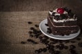 Black Forest Cake topping cherry putting on the white plate and coffee beans placed beside it Royalty Free Stock Photo