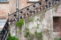 Black forged banister and stone stairs of a porch