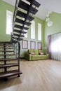 Black, forged staircase in a high, green interior