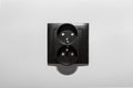 Black frame of a double electrical socket with grounding on the gray wall of the room. Royalty Free Stock Photo