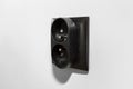 Black frame of a double electrical socket with grounding on the gray wall of the room. Royalty Free Stock Photo