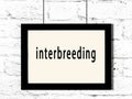 Black frame hanging on white brick wall with inscription interbreeding Royalty Free Stock Photo
