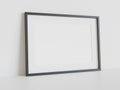 Black frame leaning on white floor in interior mockup. Template of a picture framed on a wall 3D rendering Royalty Free Stock Photo