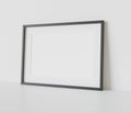 Black frame leaning on white floor in interior mockup. Template of a picture framed on a wall 3D rendering Royalty Free Stock Photo