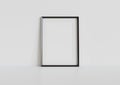 Black frame leaning on white floor in interior mockup. Template of a picture framed on a wall 3D rendering Royalty Free Stock Photo