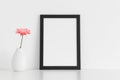 Black frame mockup with a chrysanthemum in a vase on a white table. Portrait orientation Royalty Free Stock Photo