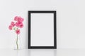 Black frame mockup with pink roses in a glass vase on a white table.Portrait orientation Royalty Free Stock Photo