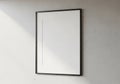 A black frame with a white mat board is mounted on a textured gray wall Royalty Free Stock Photo